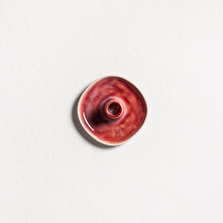 Red Christmas candle holder in white stoneware — a small round dish with a central taper-candle holder, deep red glaze fading to a white base, handmade in Portugal.